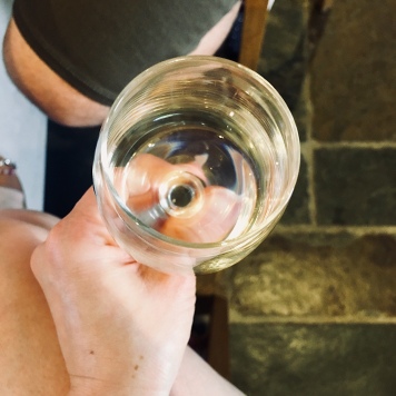 Hand holding a glass of white wine.